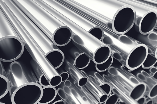 Heap of shiny metal steel pipes with selective focus effect